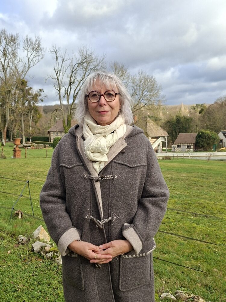 Madame BESNIER, en fond le décor d'un beau paysage saint-aubinois, un jour de ciel clairsemé