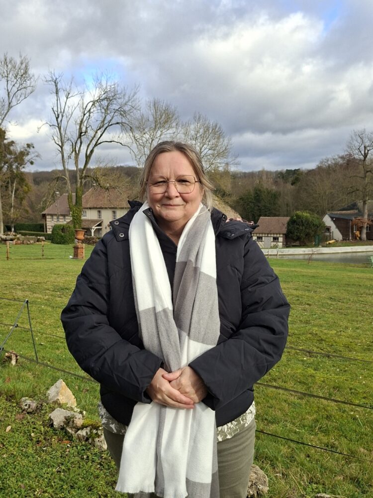 Madame BONNEAU, en fond le décor d'un beau paysage saint-aubinois, un jour de ciel clairsemé