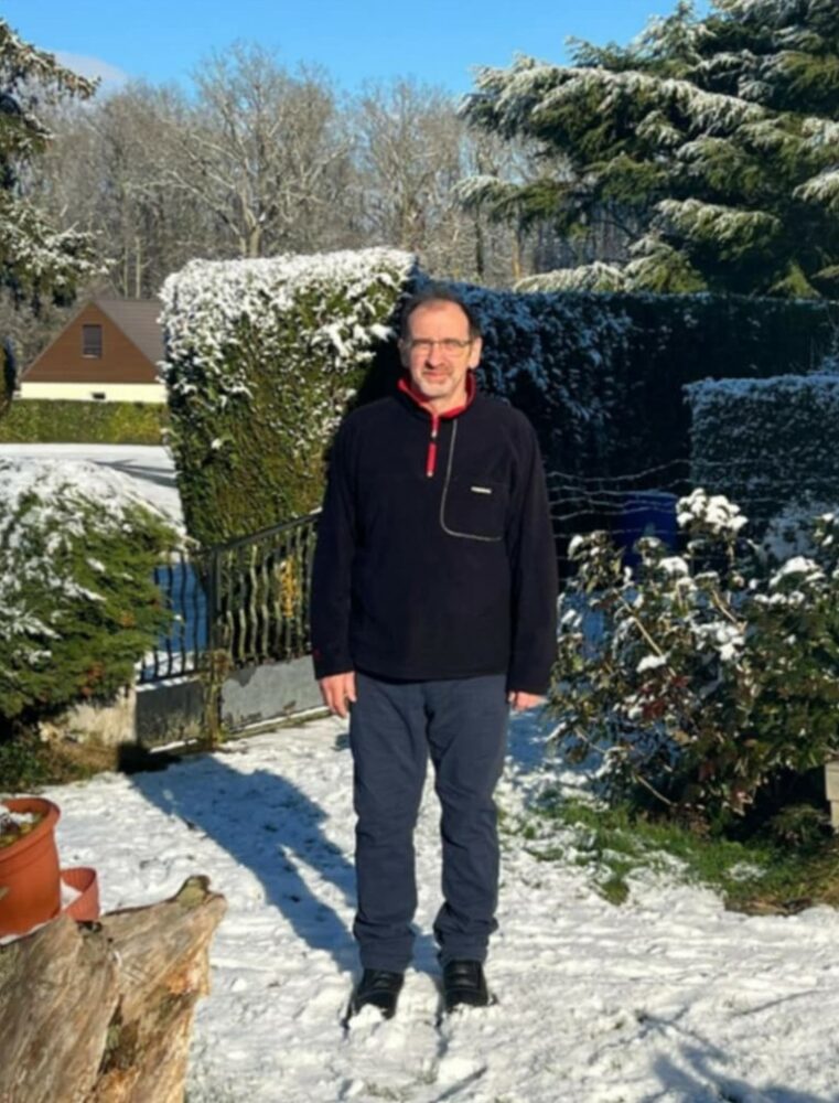 Monsieur IGNASIAK, en fond le décor d'une cour enneigée